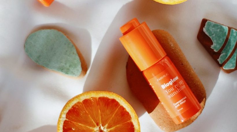 Skincare products laid out with sliced oranges